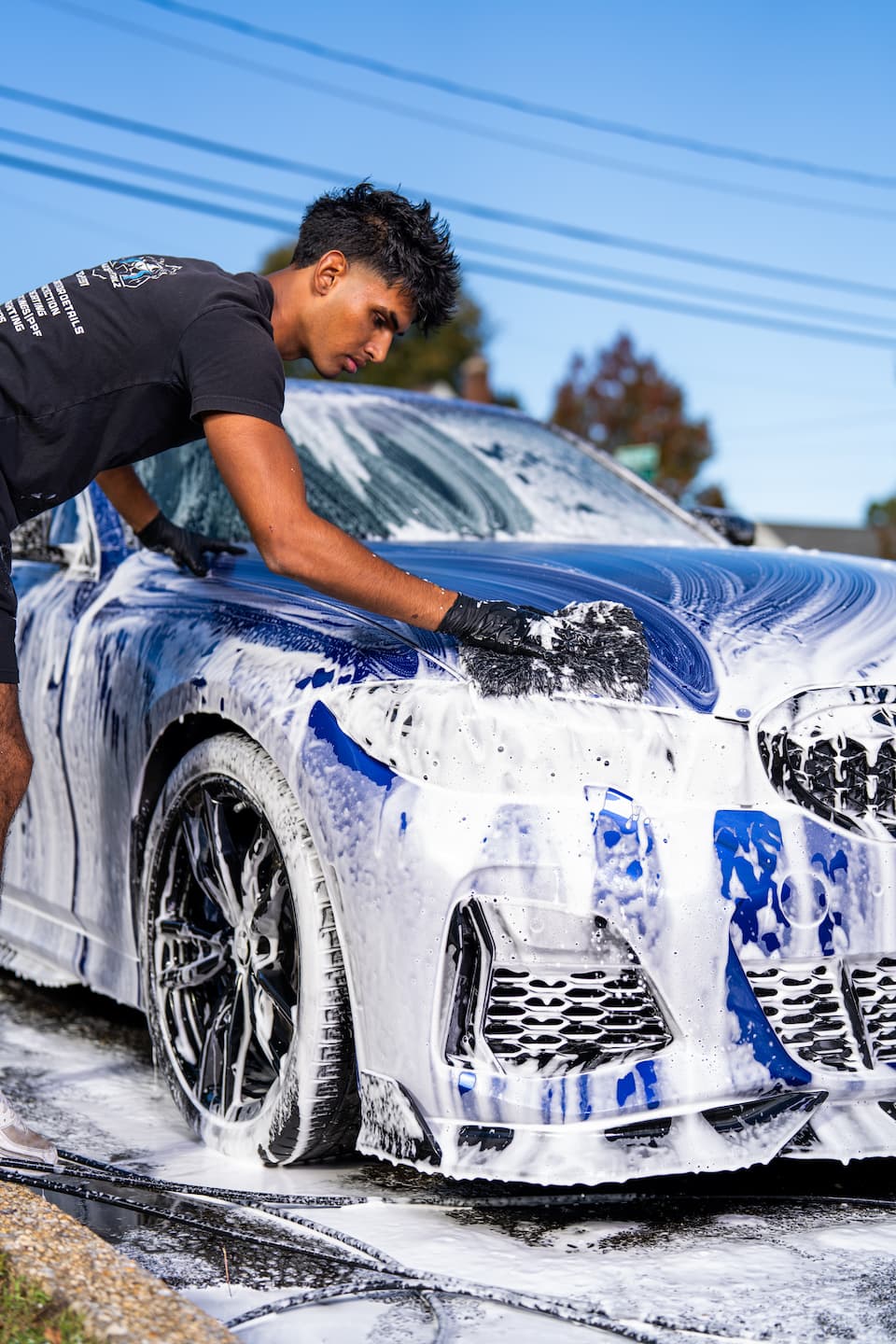 Autospa Detailz technician detailing a luxury vehicle in the Mineola, NY shop