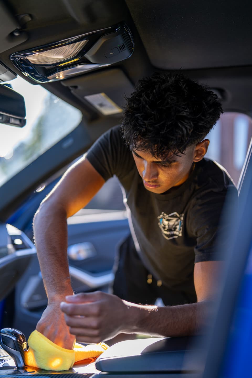 Autospa Detailz technician detailing a luxury vehicle in the Mineola, NY shop